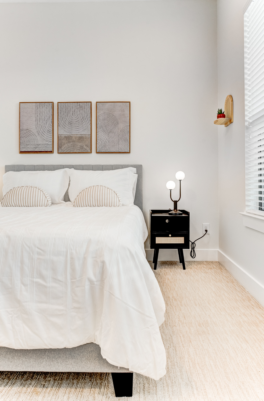 Guest bedroom detail with framed art and rattan accents
