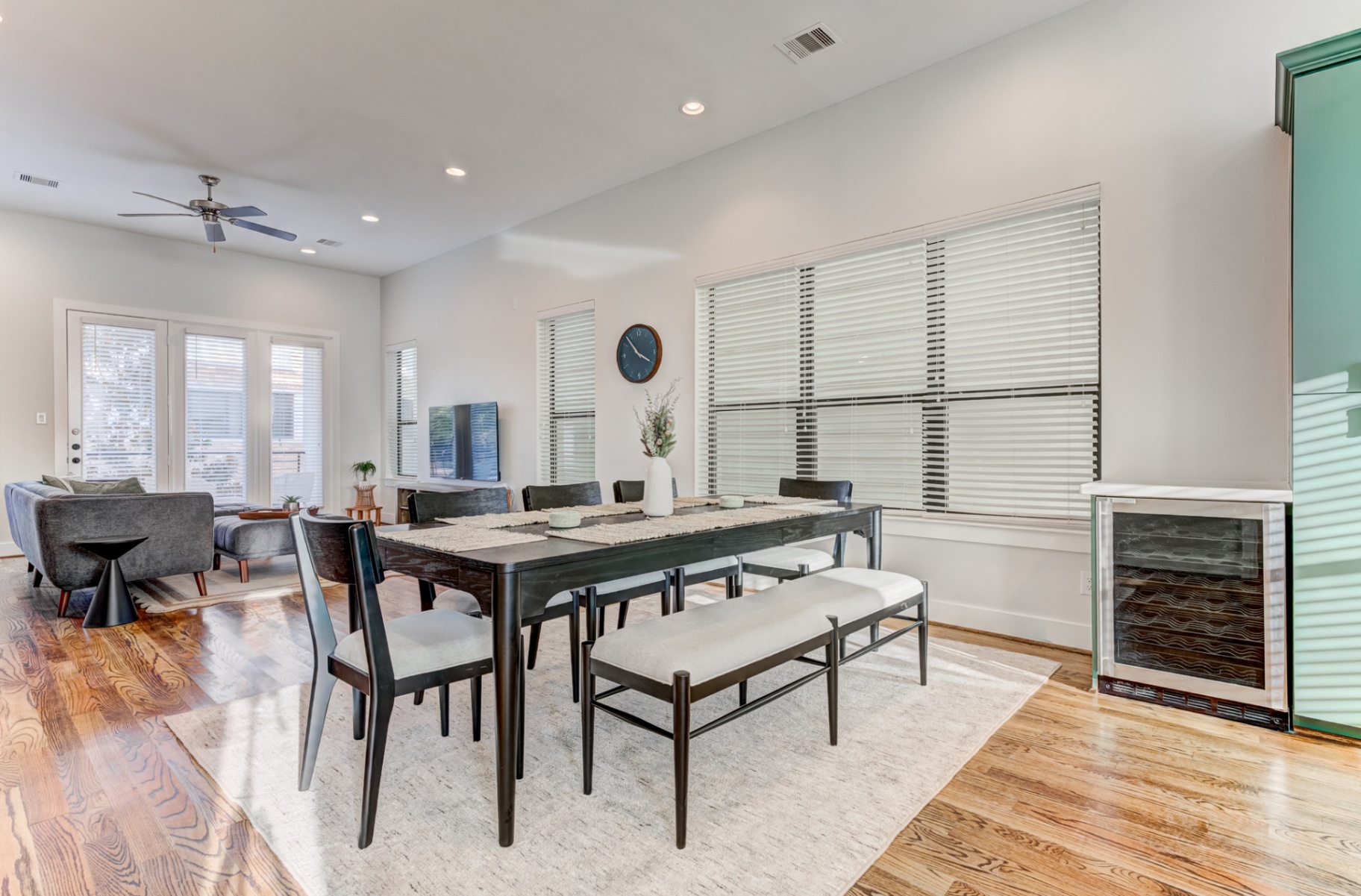 Dining table for eight with wine fridge and living area beyond