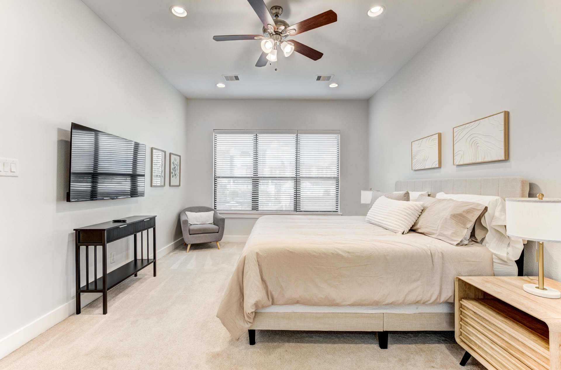 Primary bedroom with king bed and wall-mounted TV