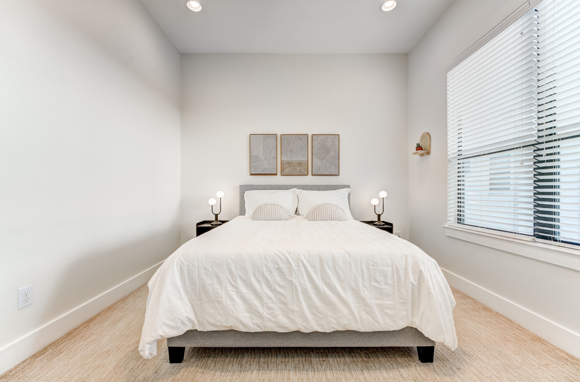 Guest bedroom queen bed framed by matching nightstands